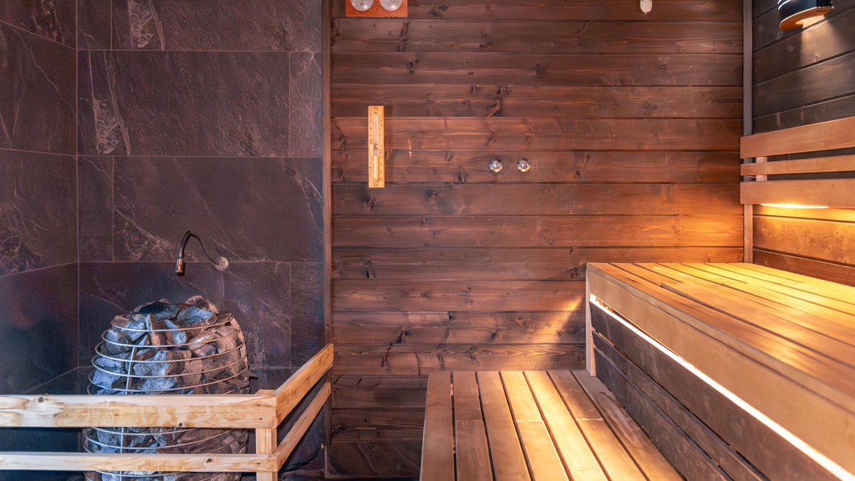 sauna-with-stones-thermometer-warm-benches-light-nordic-wellness-1200x800 Cropped